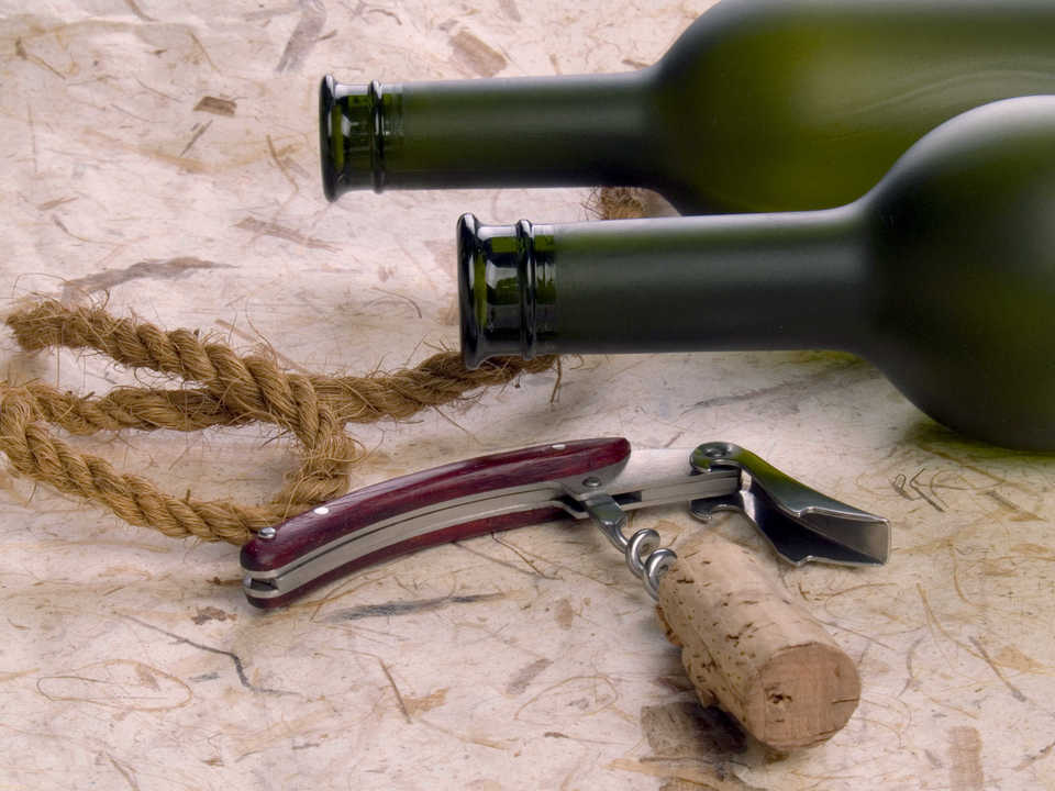 Close up of vine botles and corkscrew on the natural background