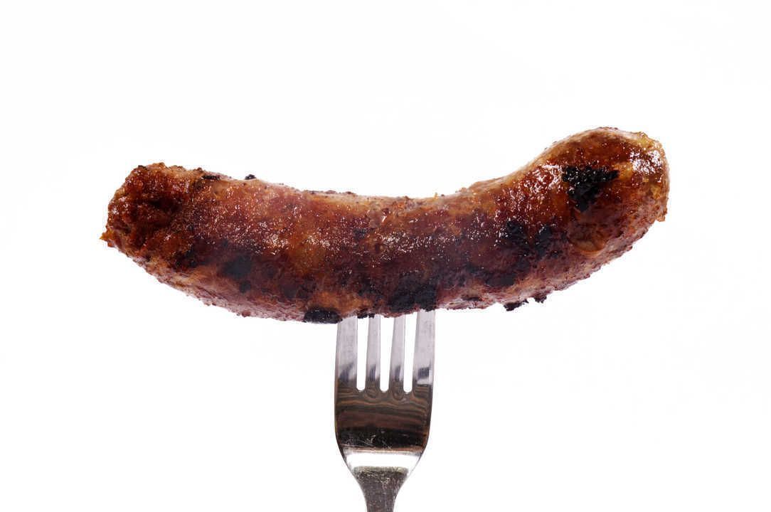 Sausage on fork isolated on white
