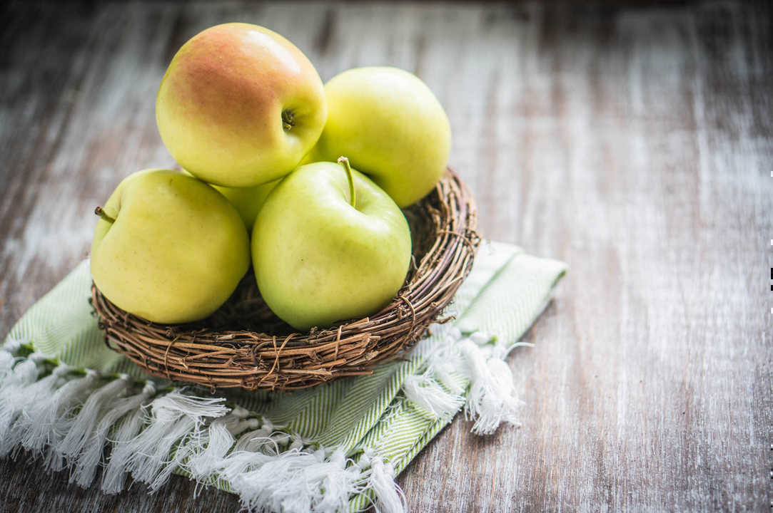 Apples in a basket on rustic background