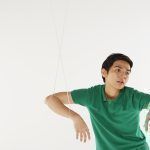 Man being pulled by strings, like a puppet