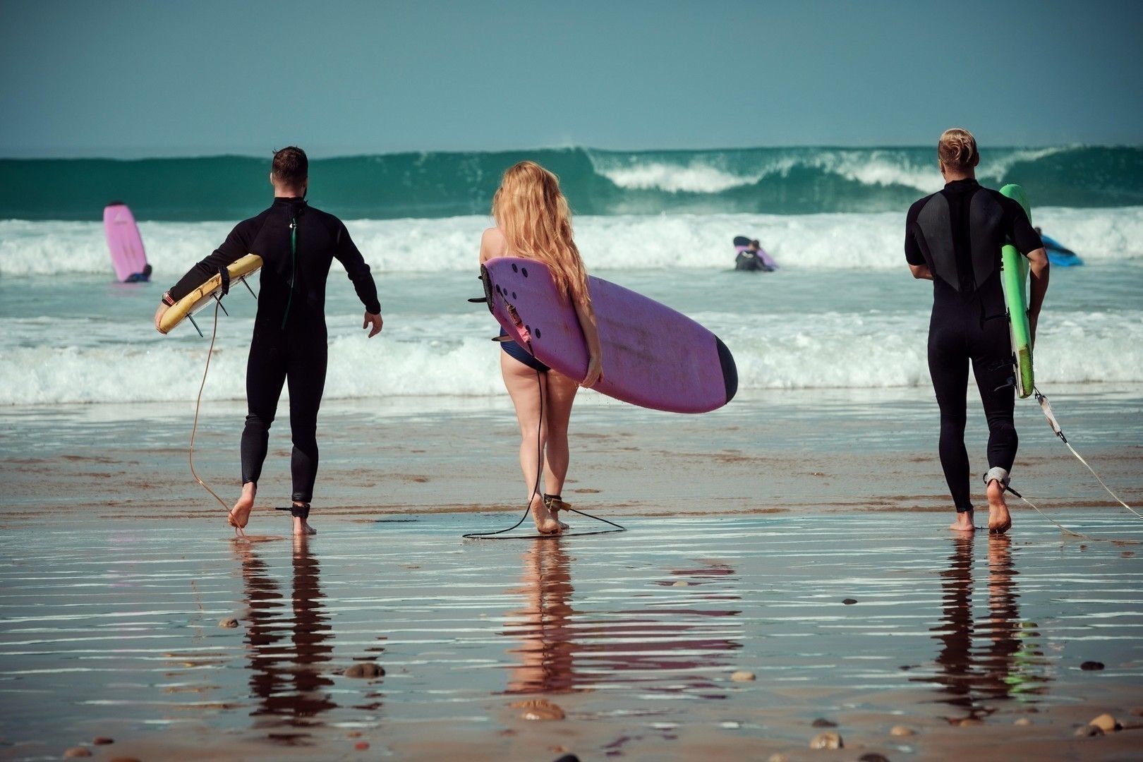 Surfer friends on a beach with a surfing boards
