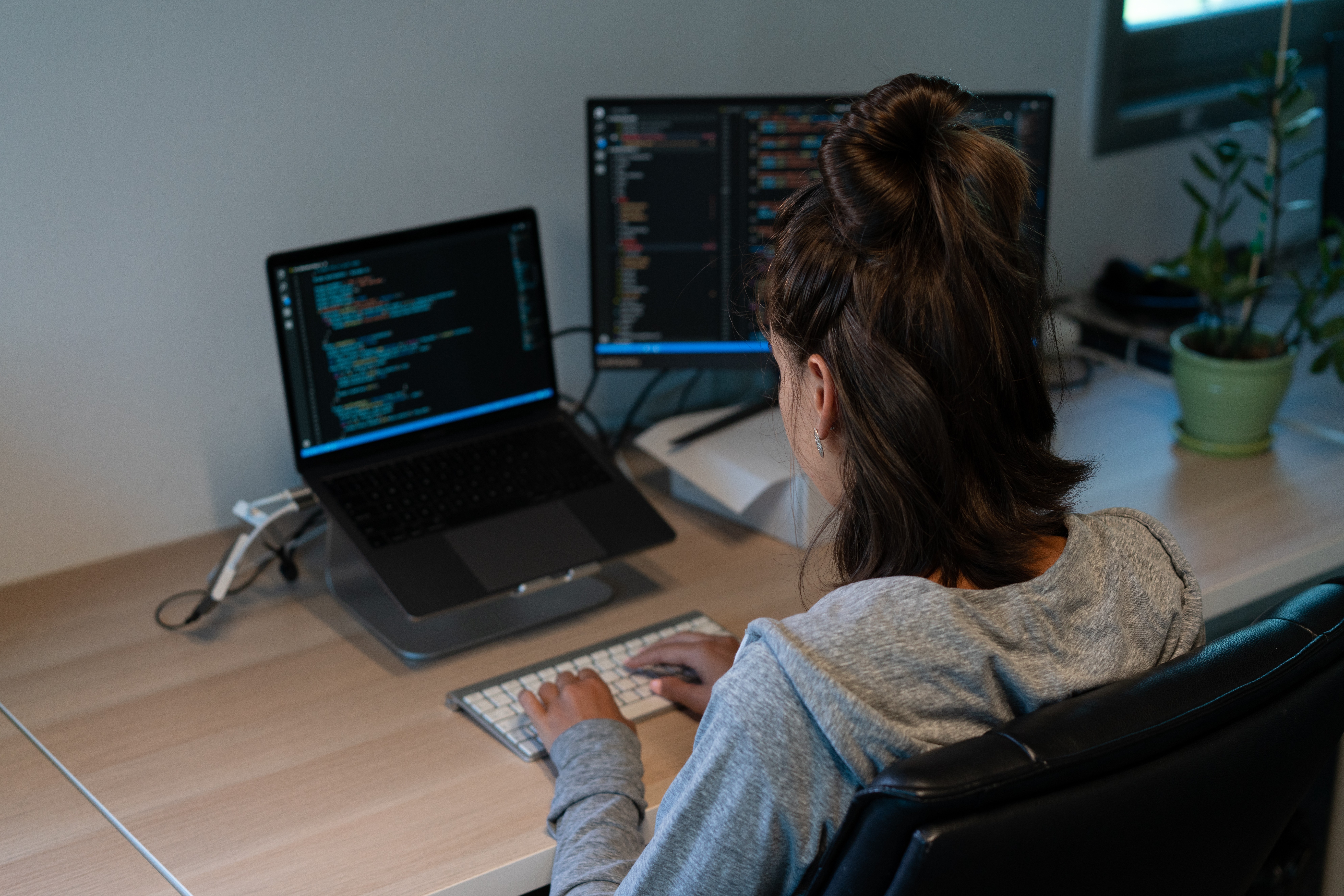 Woman programming on two monitors